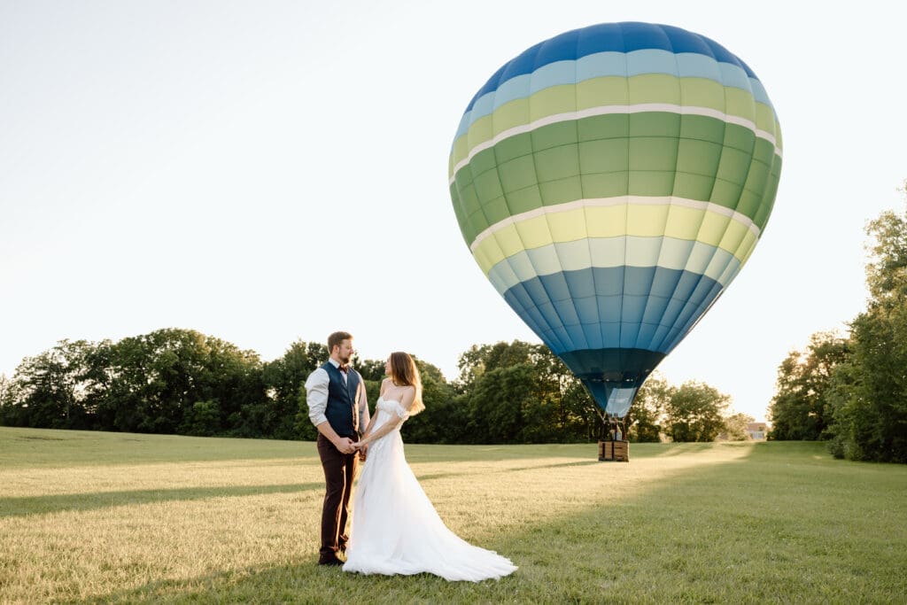 Couple in front of a hot air balloon.