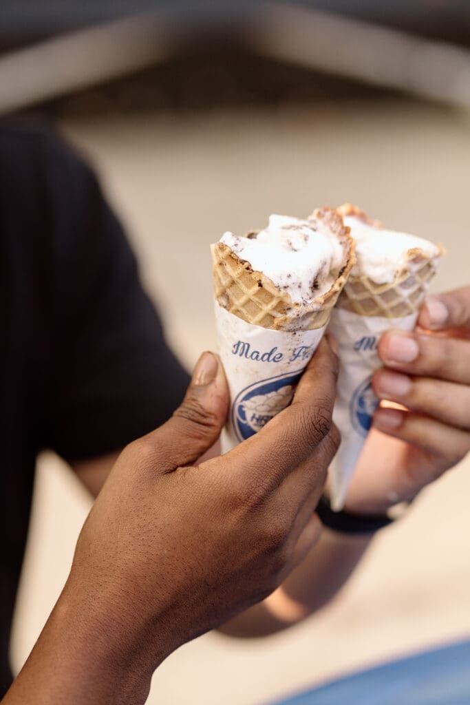 Couple toasting ice cream cones.
