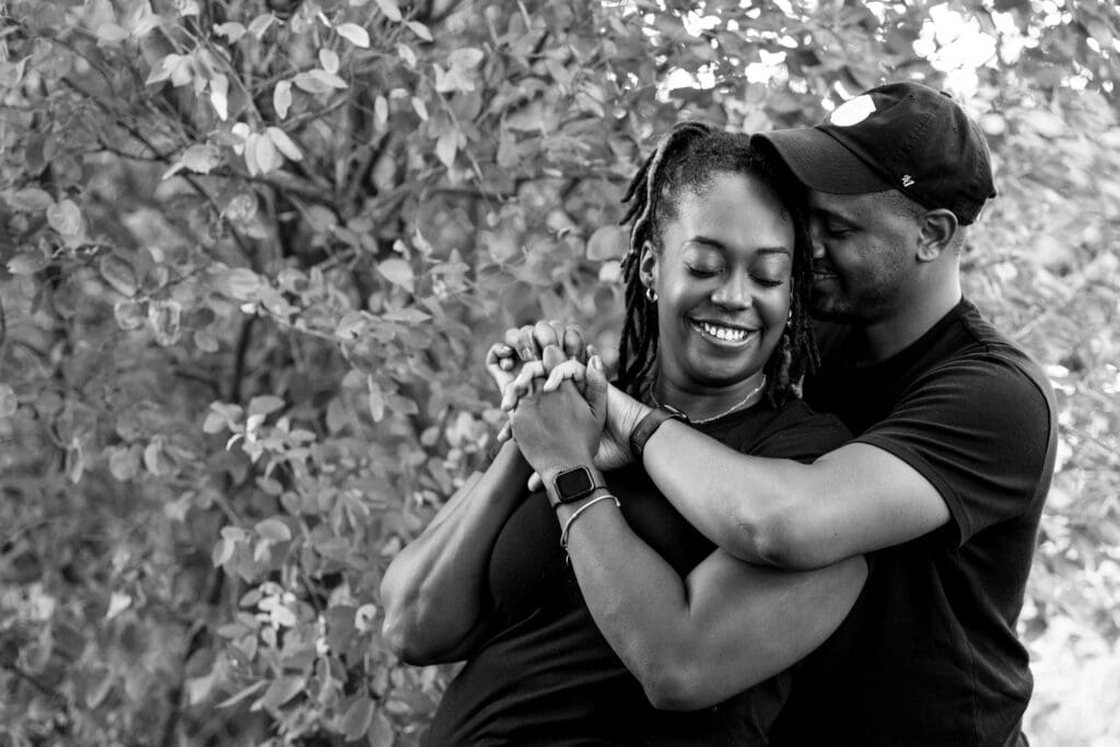 Man embracing woman from behind.