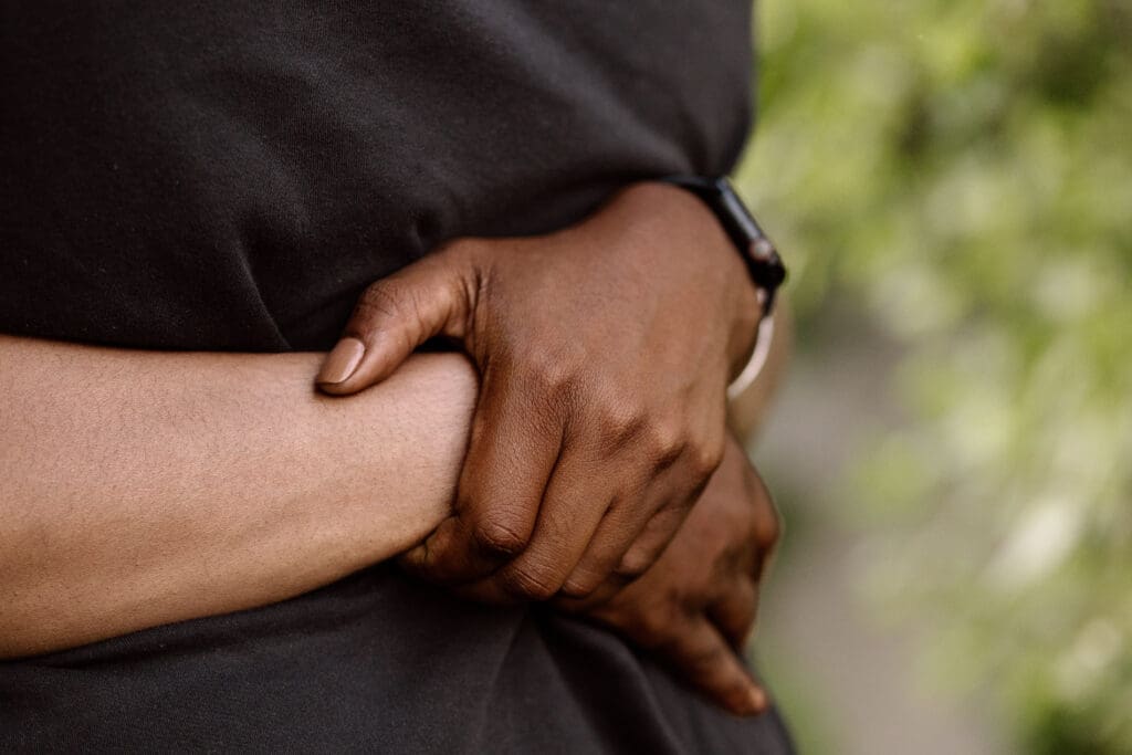 Detail of woman's arms wrapped around her boyfriend.