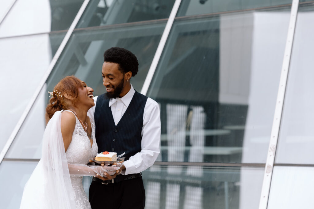 Elopement couple eating cake together outside of the Akron Art Museum.
