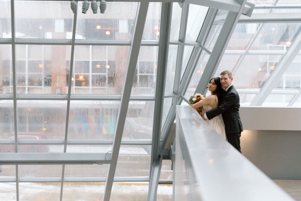 Couple embracing in the atrium of the Akron Art Museum.