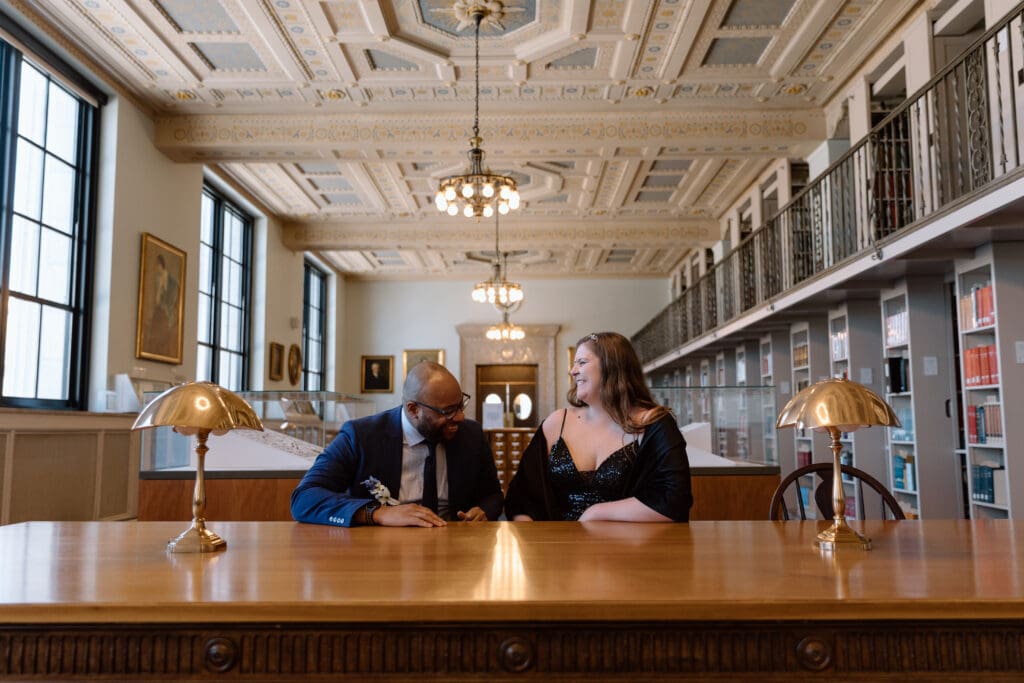 Couple laughing while sitting at the special collections table in the Cleveland Public Library.