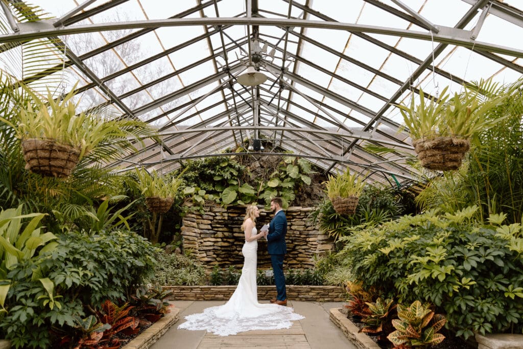 Couple saying vows at Rockefeller Park Greenhouse in Cleveland.