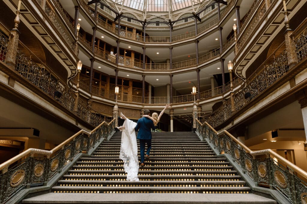 Groom carrying bride upstairs at the Cleveland Arcade.