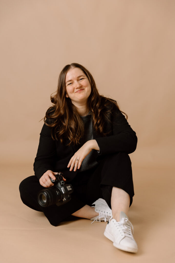 Desiree sitting and holding her camera.