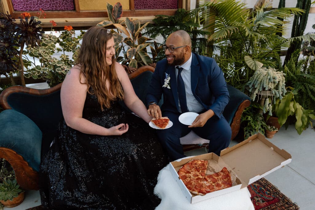 Couple eating pizza on their elopement day.