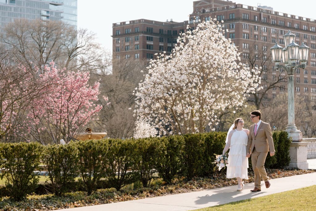 Couple walking along a path at Wade Lagoon in Cleveland during cherry blossom season.