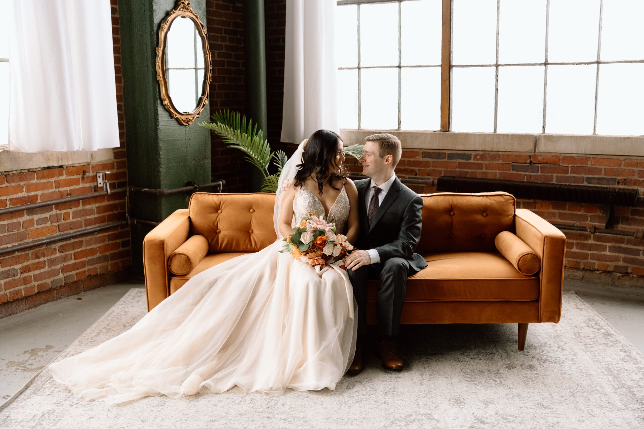 Couple sitting on a couch and looking at each other during their winter elopement in Akron, Ohio.