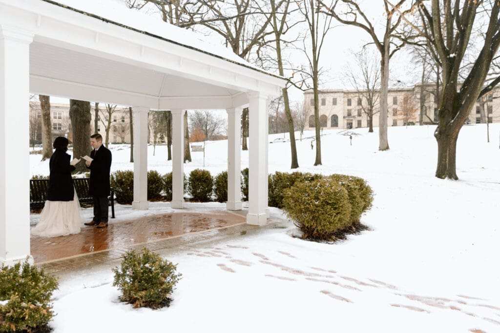 Couple saying their vows under a gazebo during a winter elopement in Ohio.