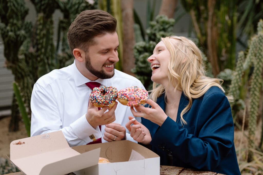 Elopement couple toasting with sprinkle donuts during their elopement in Cleveland, Ohio.