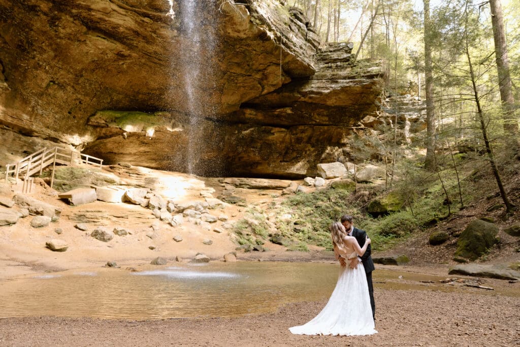 Couple embracing near the waterfall at Ash Cave in Hocking Hills State Park.