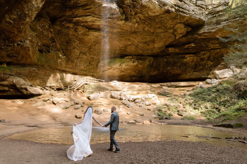 Couple running near the waterfall at Ash Cave.