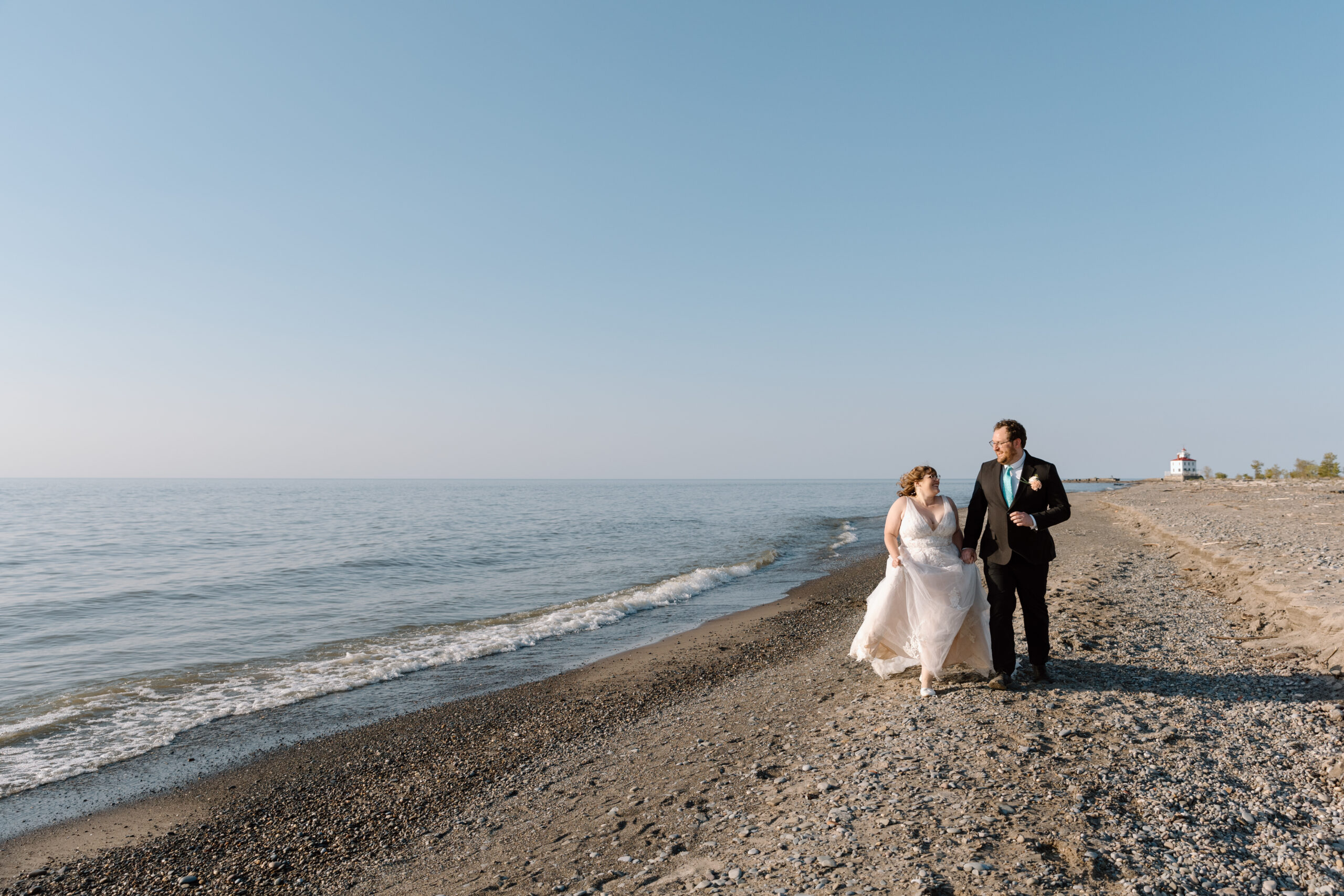 Couple running down the beach on Lake Erie.