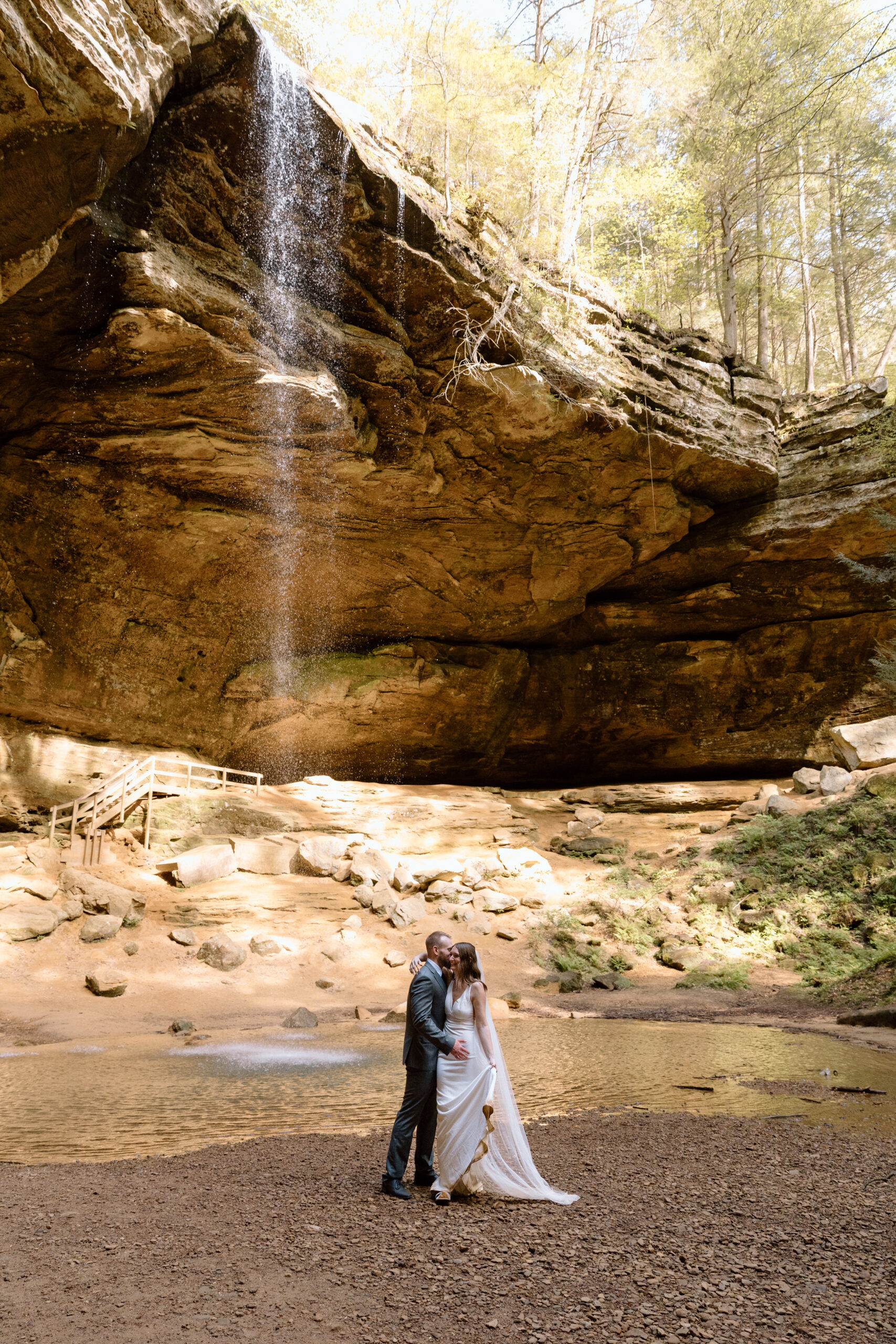 Couple embracing in front of the Ash Cave waterfall.