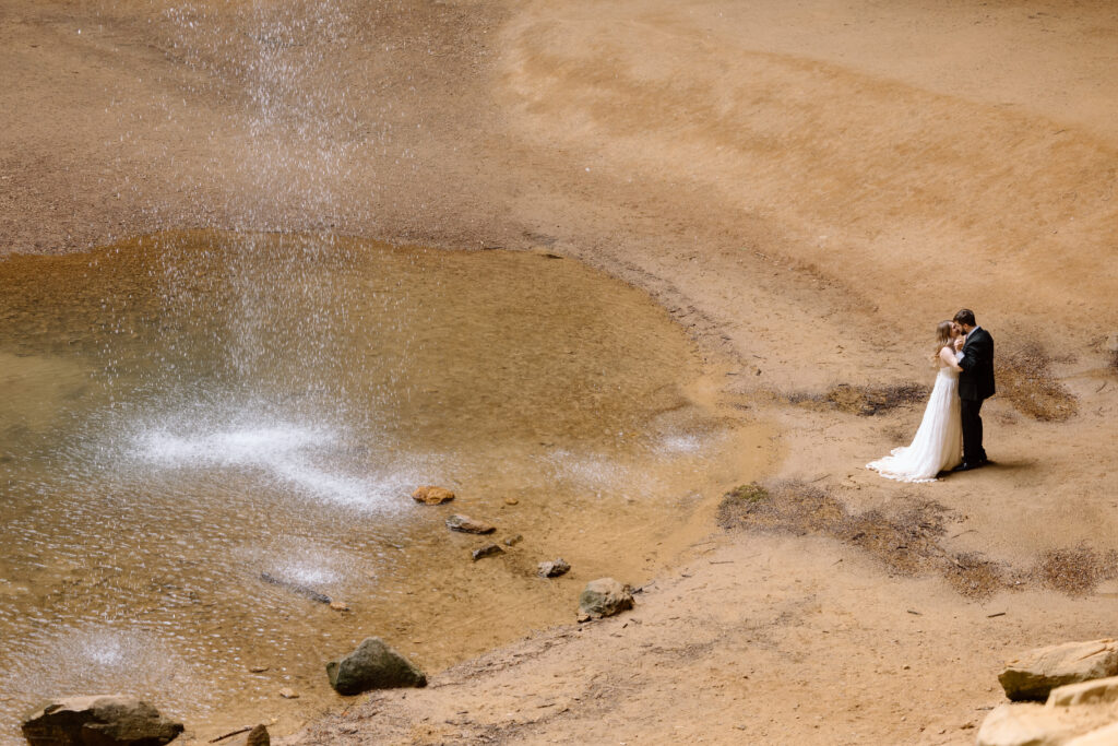 Couple embracing next to the Ash Cave waterfall.