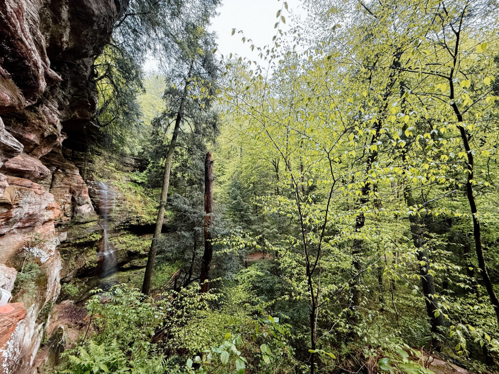 Rock House trail with the waterfall on the left and trees on the right.