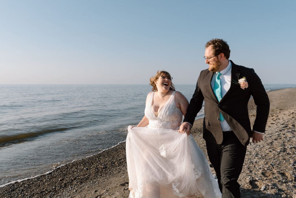 Eloping couple running down Headlands Beach.