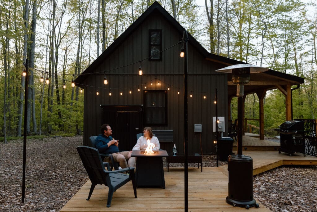 Eloping couple sitting at the fire of their Airbnb.