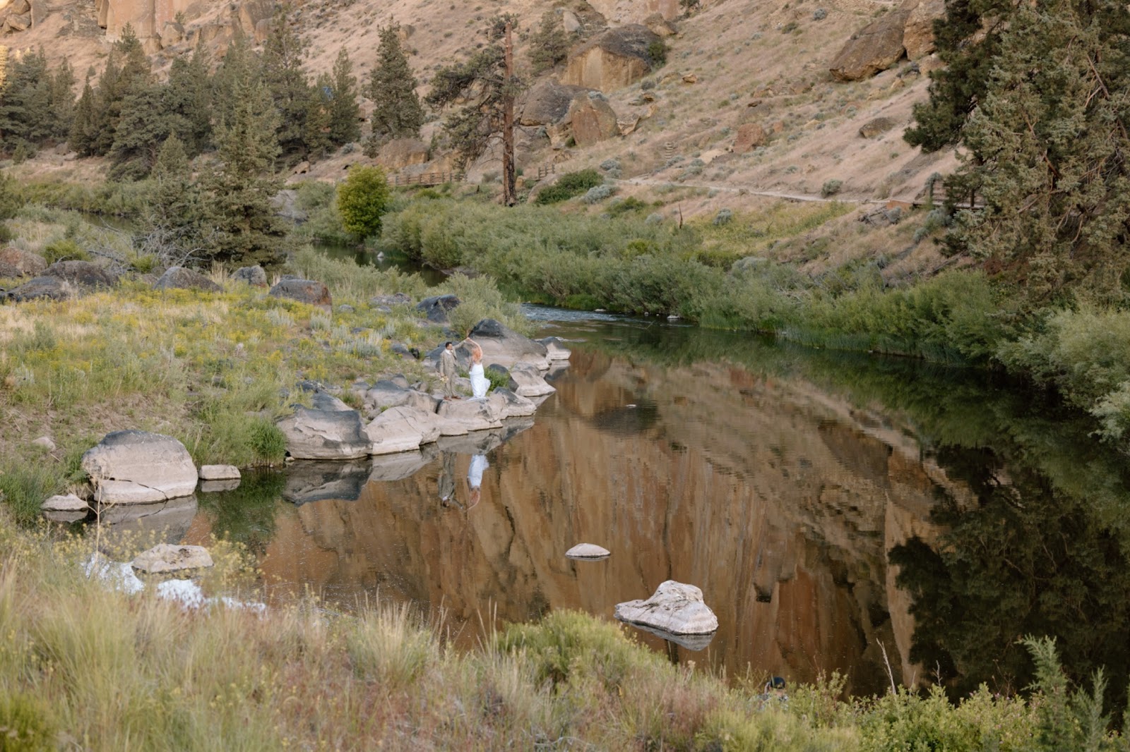 Couple twirling near the river in Smith Rock State Park in Oregon.