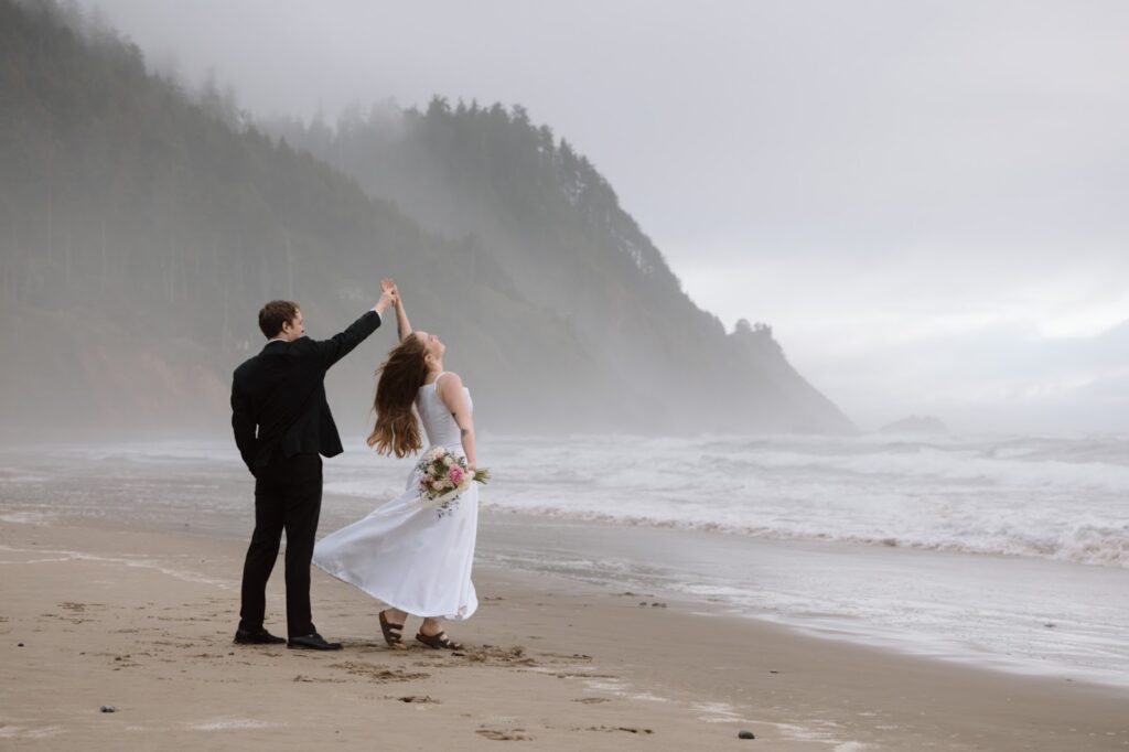 Eloping couple dancing on a beach on the Oregon Coast.