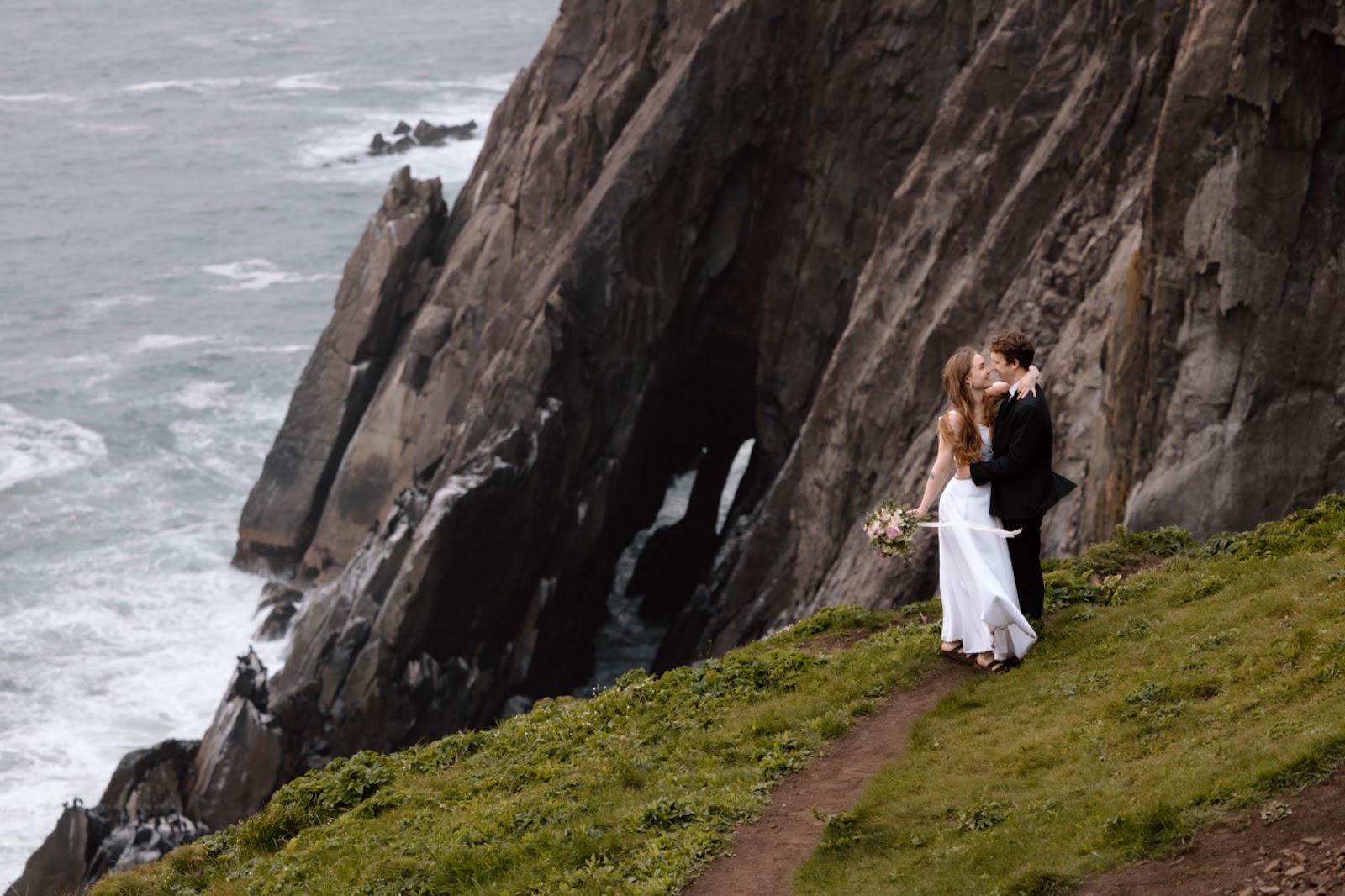 Couple eloping on the side of a cliff on the Oregon Coast.