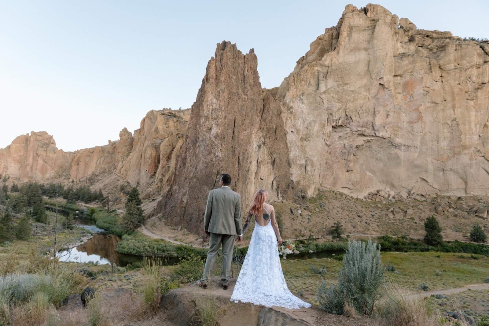Couple holding hands at Smith Rock State Park in Oregon.