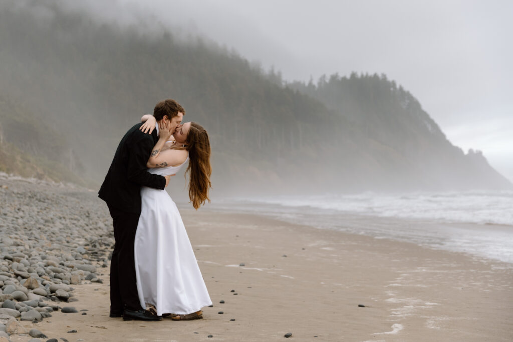 Elopement couple kissing on the beach at the Oregon Coast.