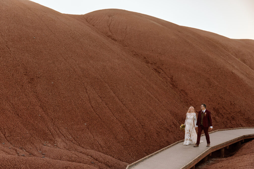 Couple walking down a boardwalk at Painted Hills in Central Oregon.