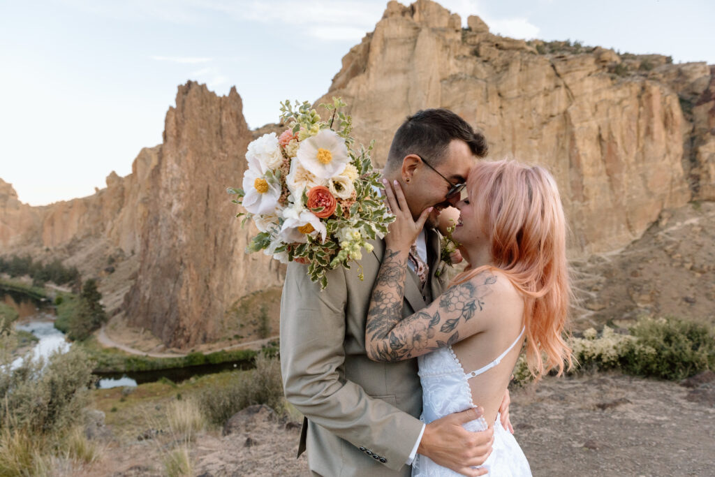 Eloping couple embracing at Smith Rock State Park in Central Oregon.