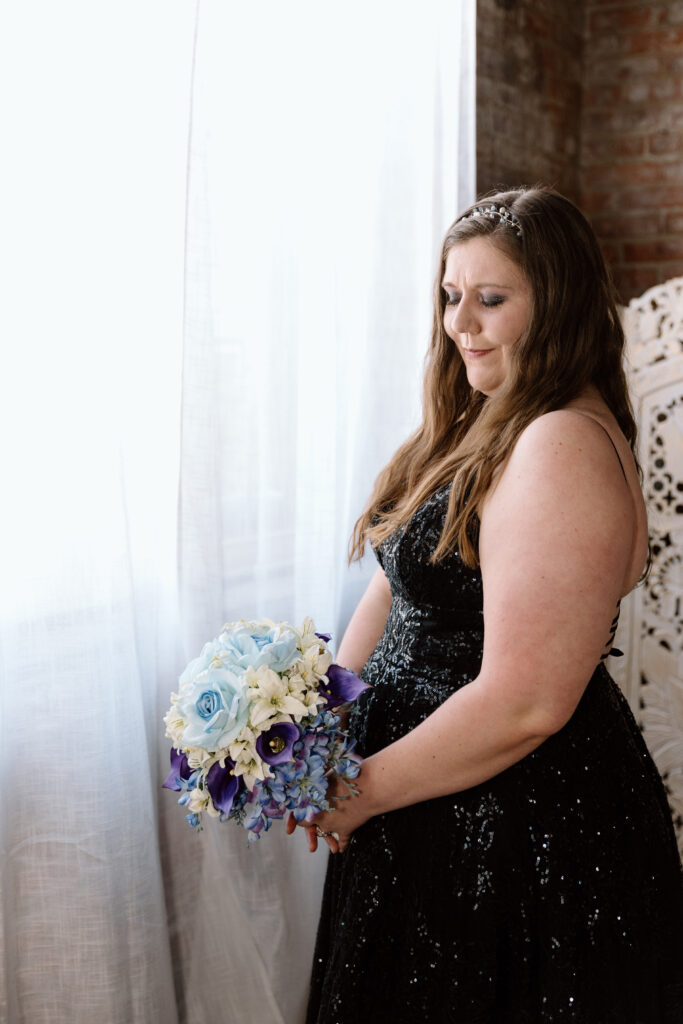 Bride standing beside a window.