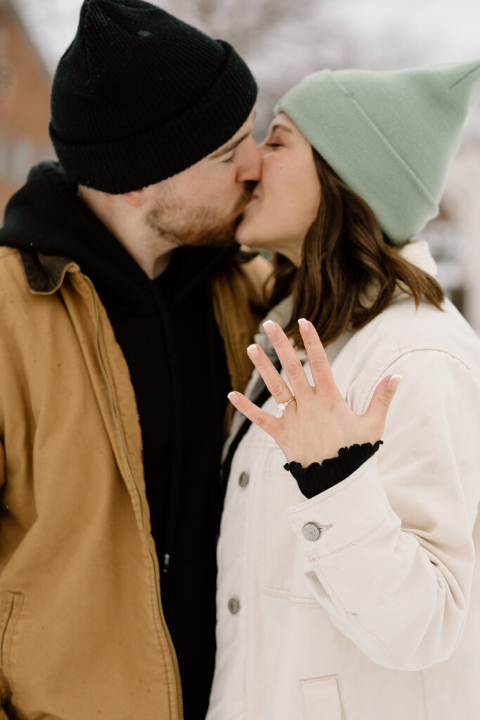 M showing off her ring while kissing R.