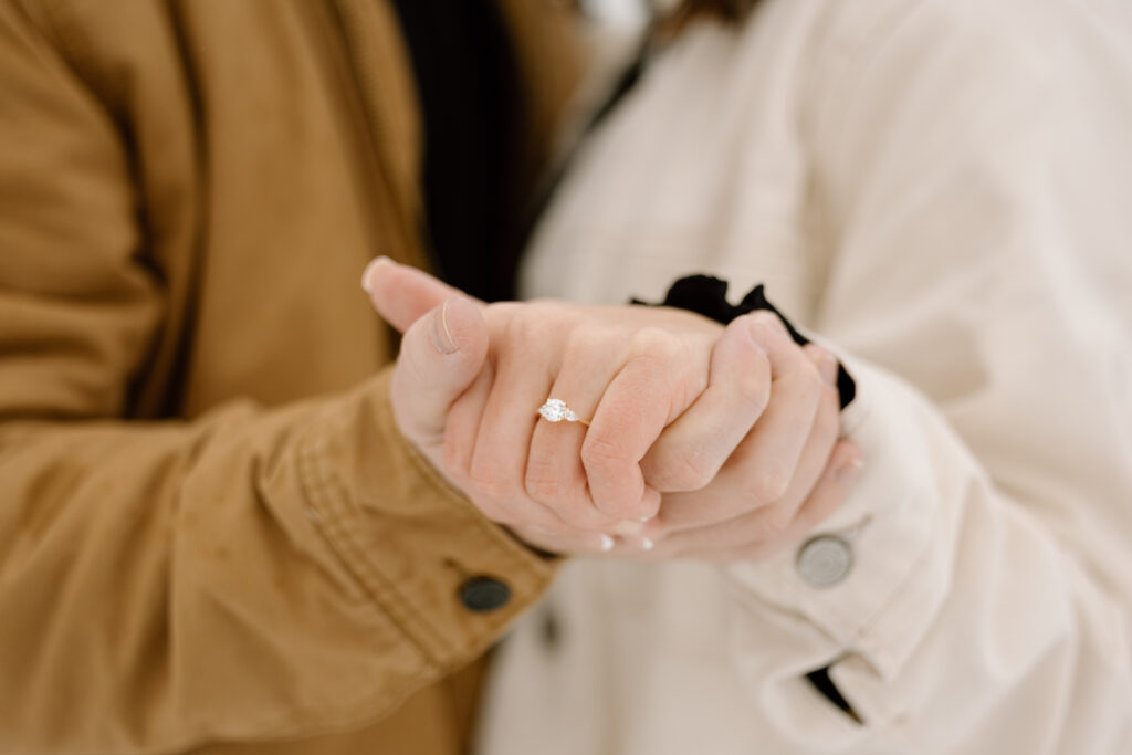 A close up of the recently engaged couple holding hands. The ring is shown.