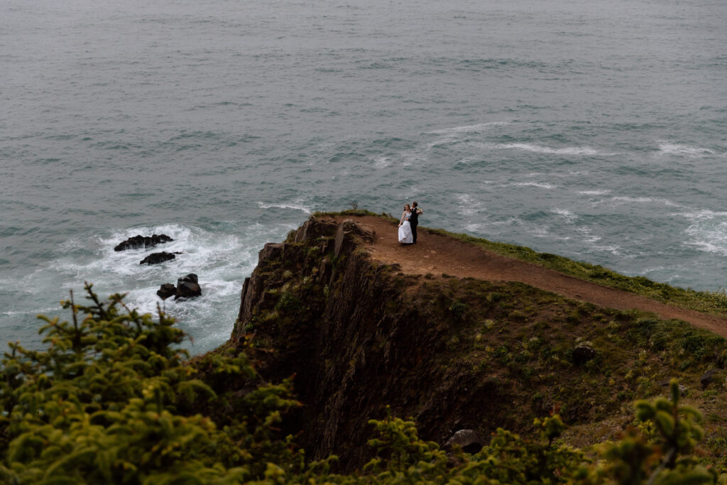 Couple embracing on a coastal cliff.
