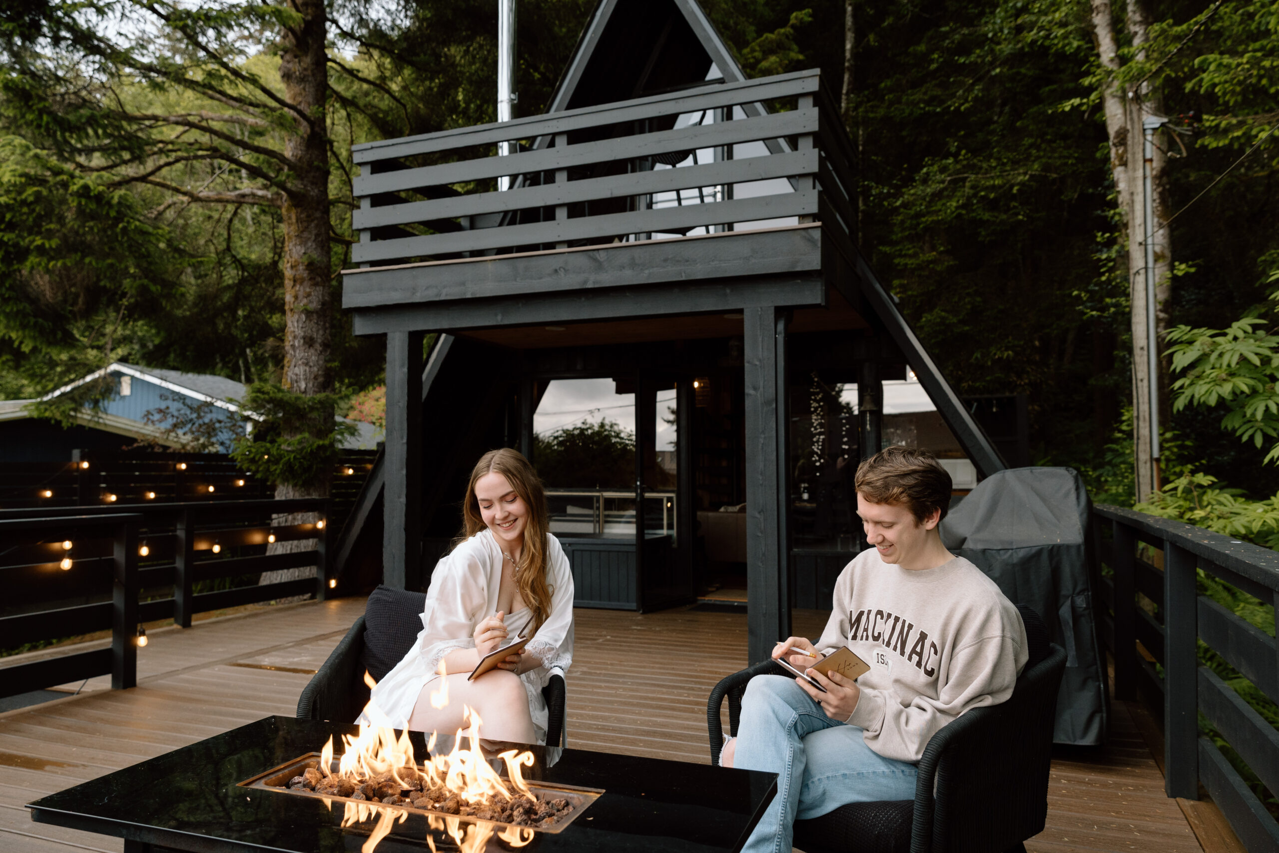 Couple writing vows in front of a fire at their A-frame cabin.