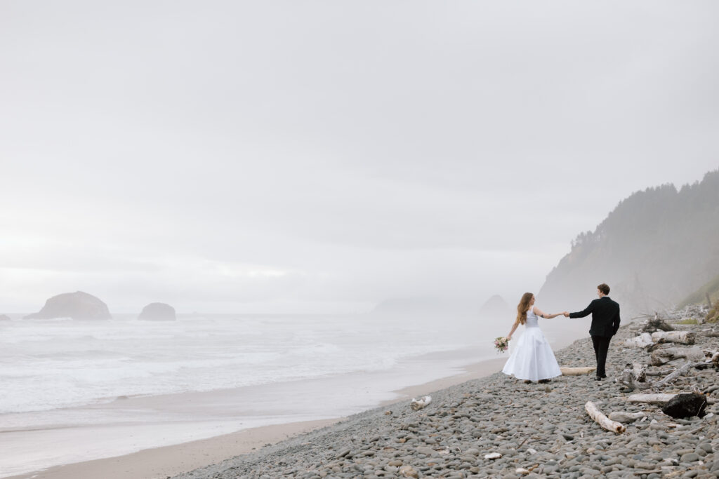 Couple walking along a rocky beach in Oswald West State Park.