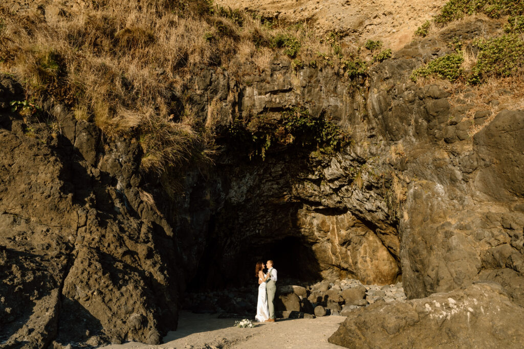 Bride and groom dancing in a sea cave.