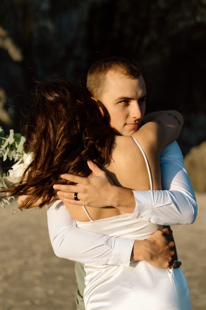 Groom hugging bride.