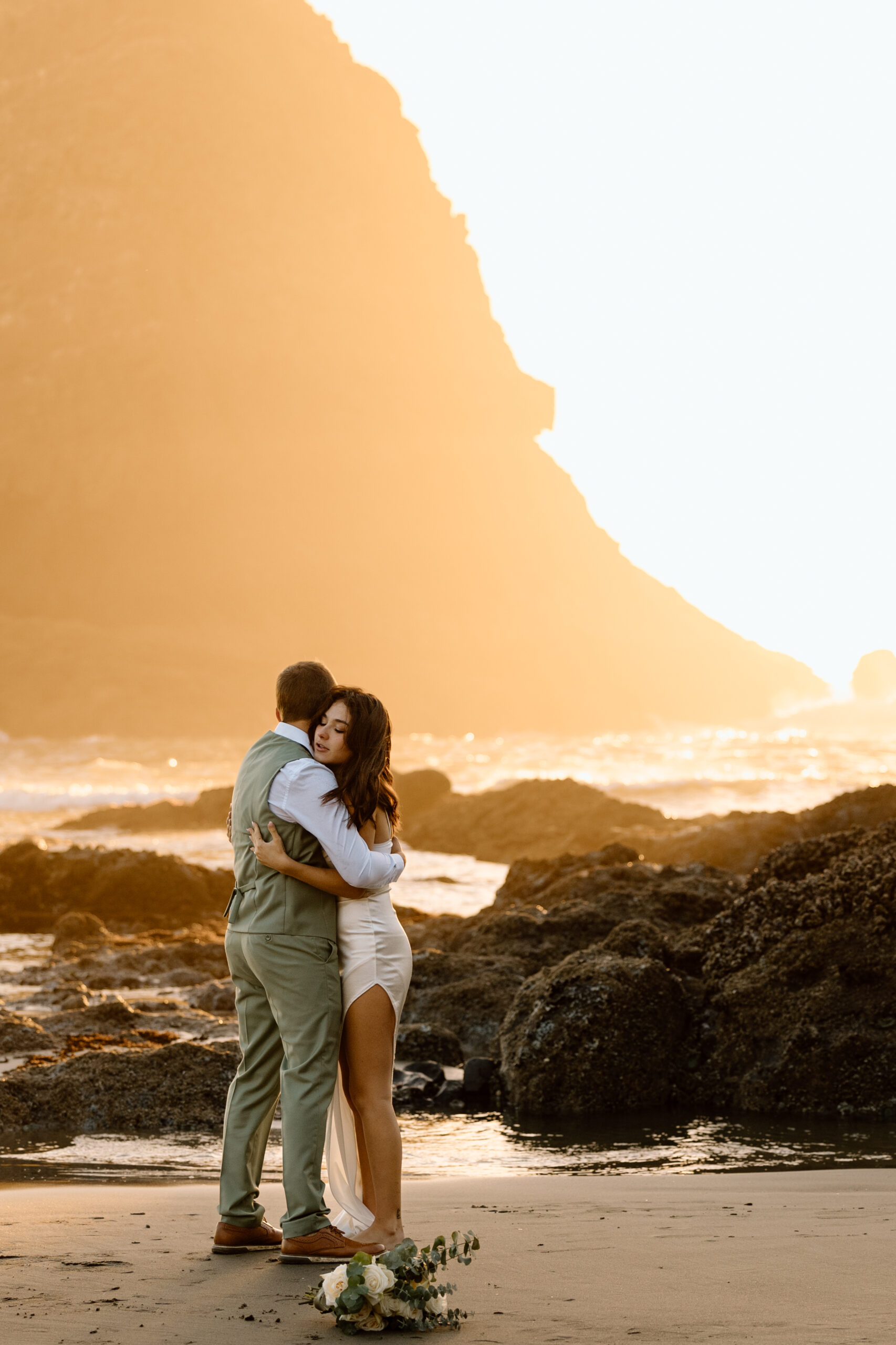 Eloping couple embracing on Heceta Head Beach.