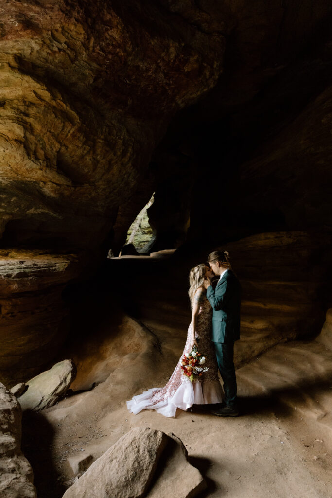 Couple standing in a patch of light in Rock House during their elopement.