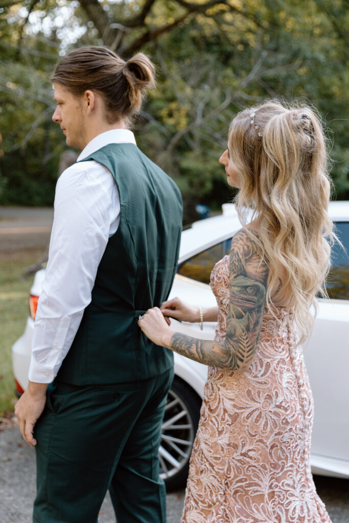 Bride tightening groom's vest.