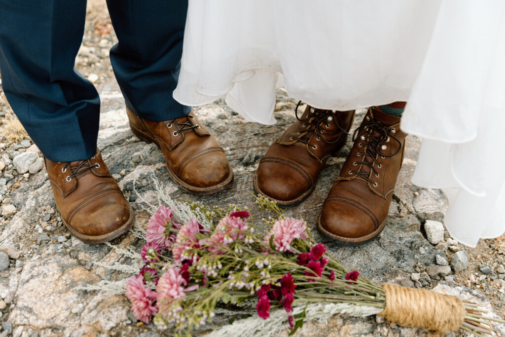 Close up of couple's boots and flowers.