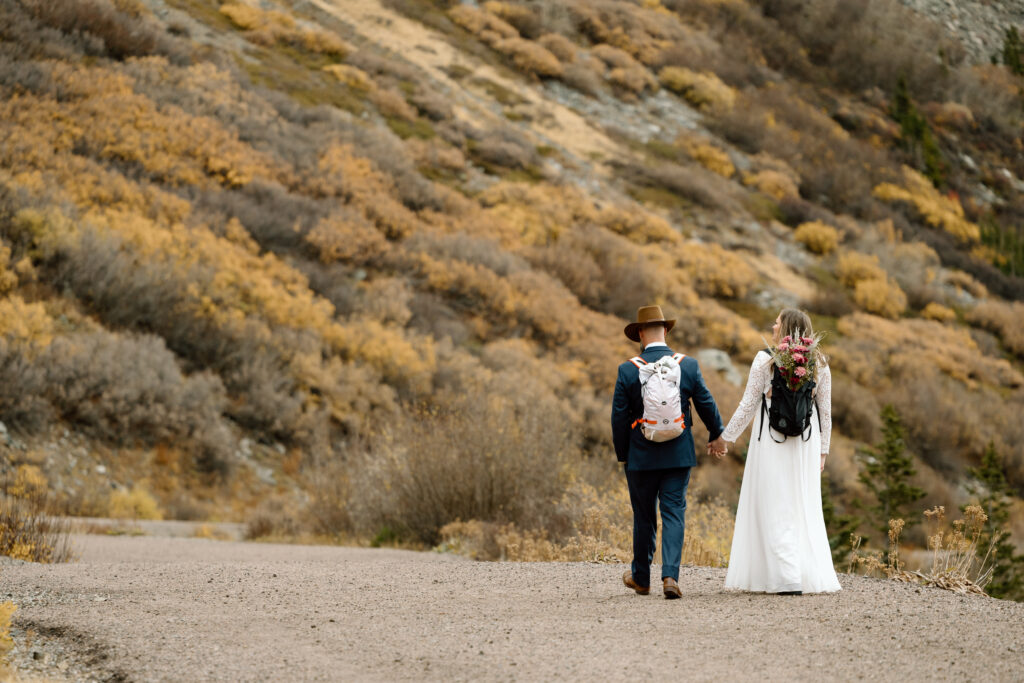 Couple holding hands while hiking in Colorado.