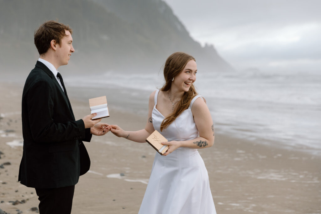 Couple saying vows while bride is looking back at the ocean.