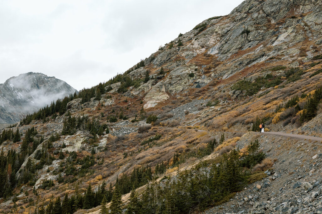 Couple in the distance with mountains around them.