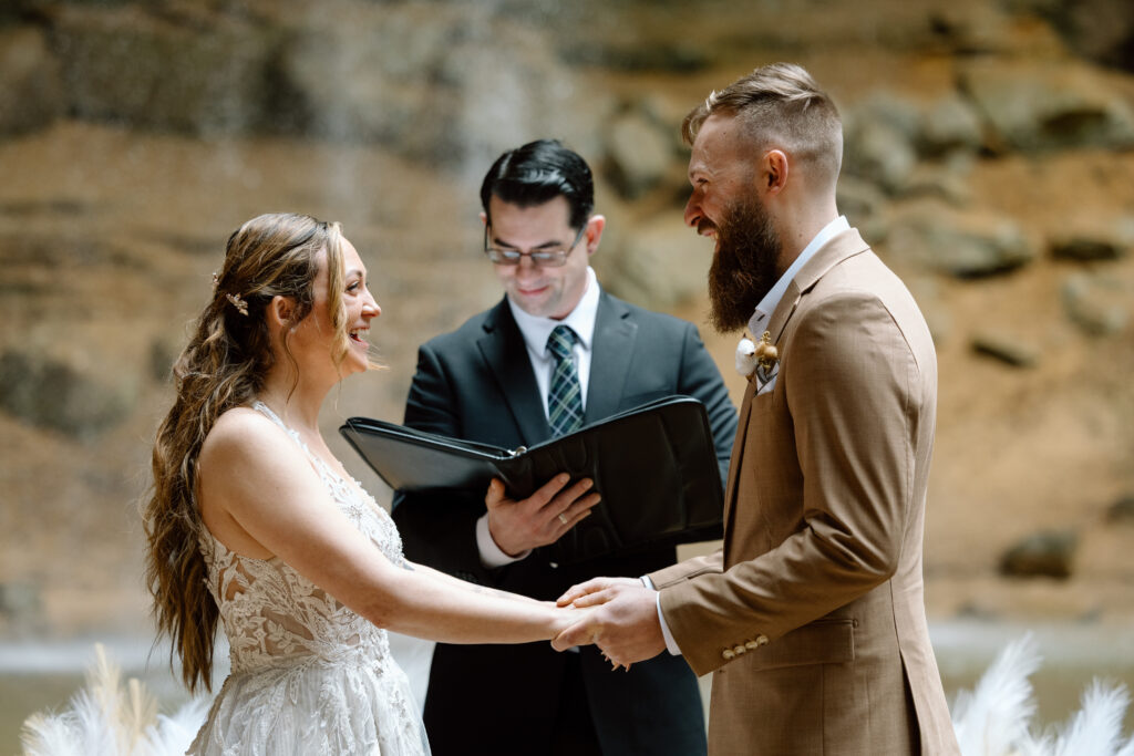 Hunter and Felicia holding hands and laughing during their vows.