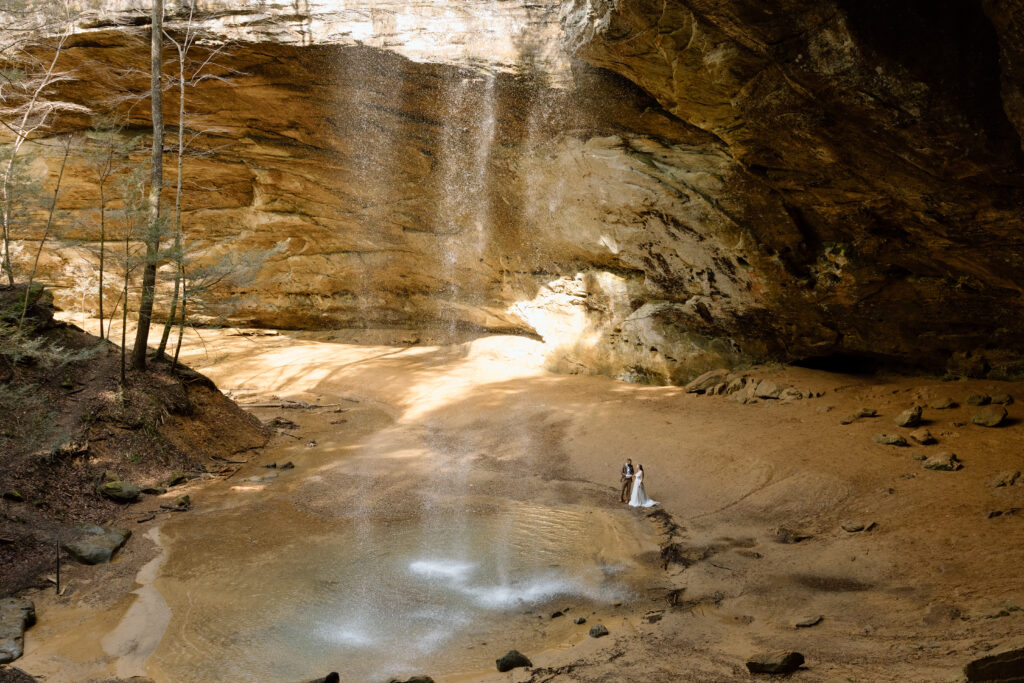 Elopement couple standing next to the waterfall in Ash Cave.