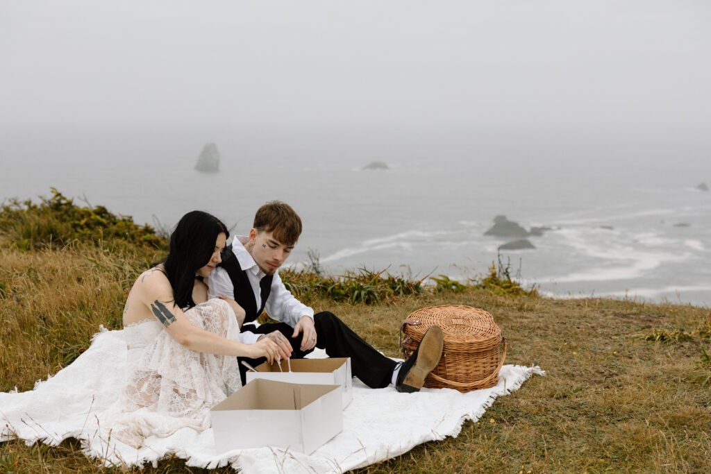 Couple eating cake during a picnic on the coast.