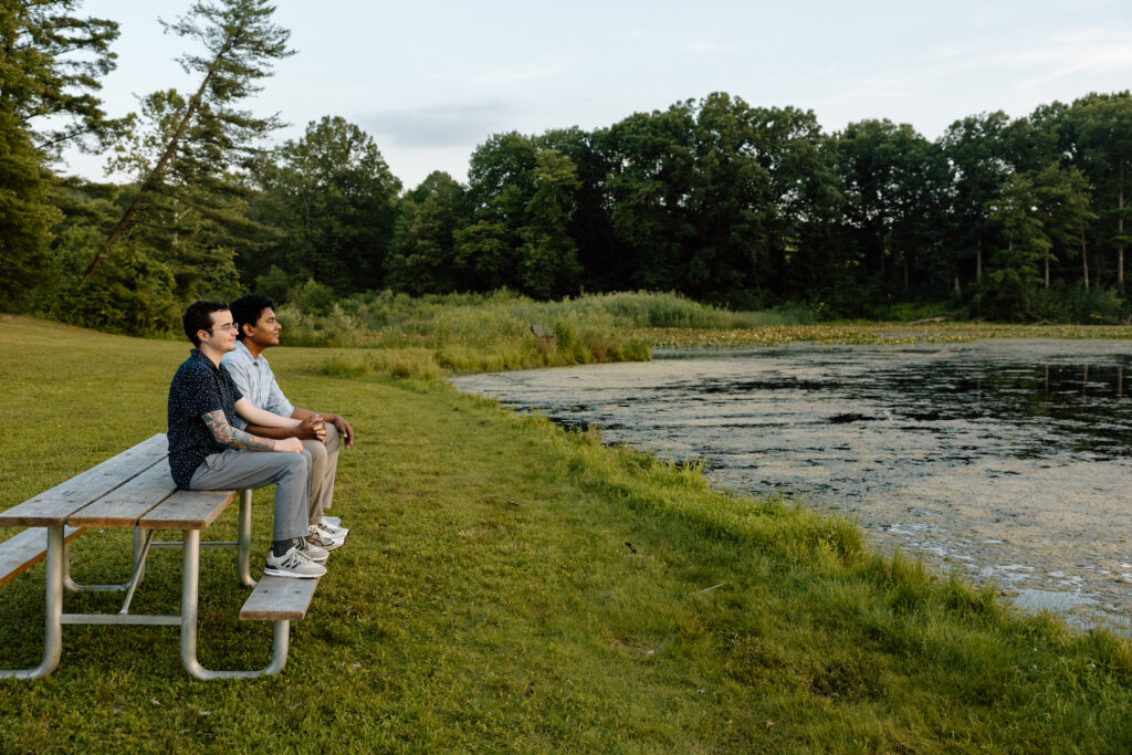 Couple sitting on a picnic bench together.