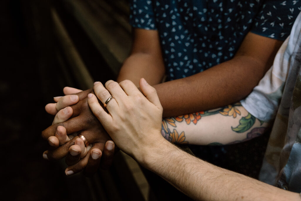 Close up of couple holdings hands.